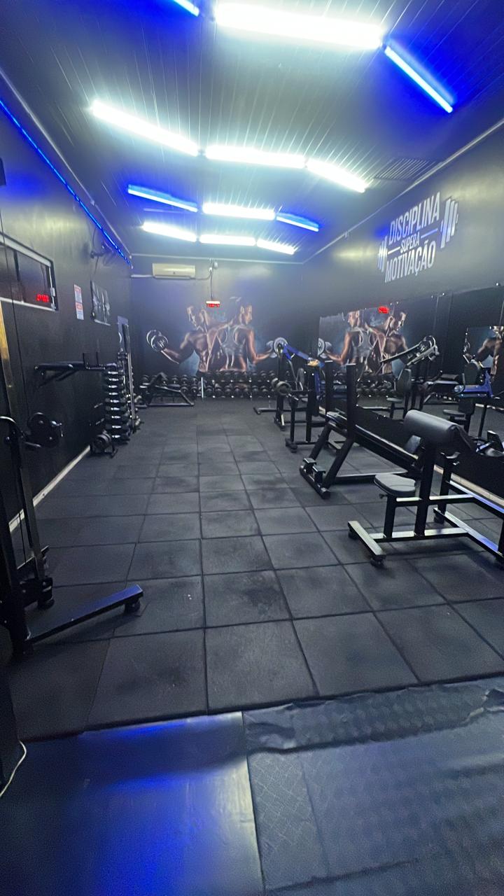 Sala de musculação da CenterFit com aparelhos, halteres e a frase Disciplina supera motivação na parede